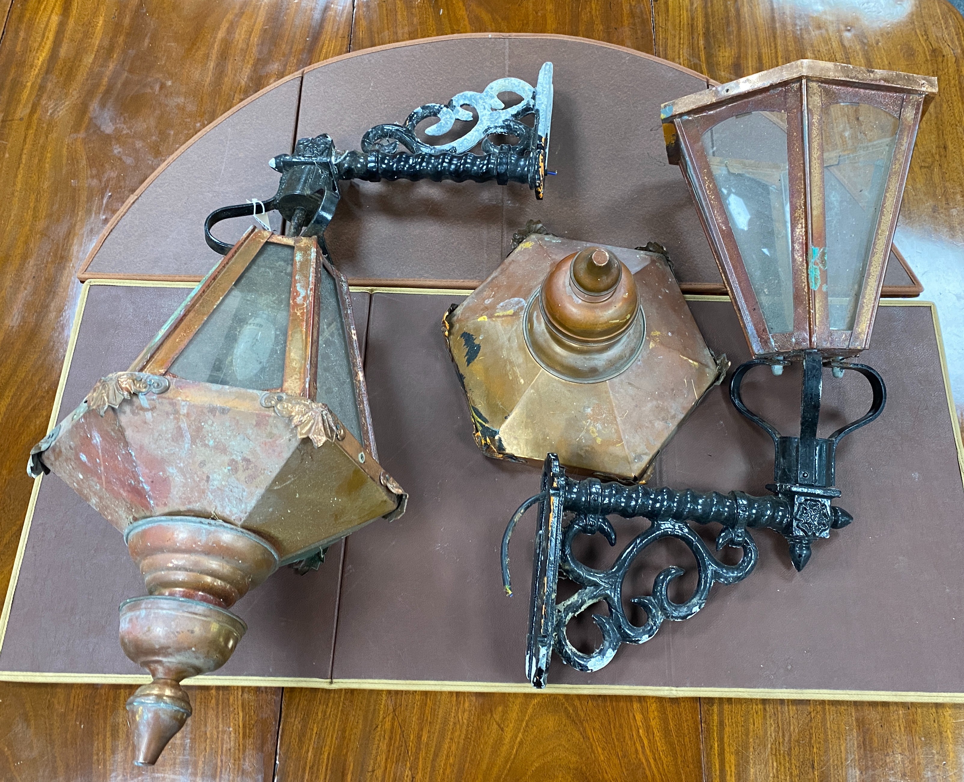 A pair of copper wall lanterns with black painted metal wall brackets, height 98cm